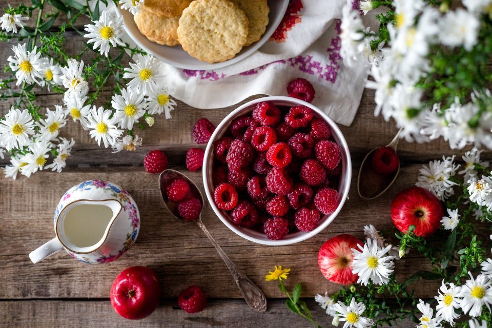 REEDUCAÇÃO ALIMENTAR E DIETA MESA COM FLORES FRUTAS VERMELHAS POTE DE BISCOITOS E LEITE